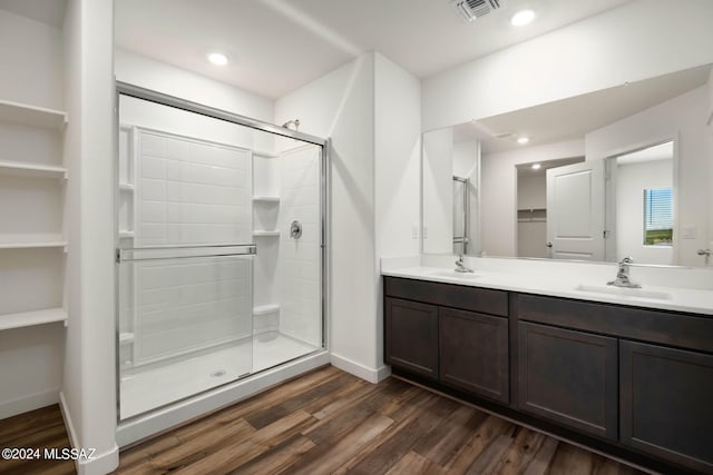 bathroom with a shower with door, vanity, and hardwood / wood-style flooring