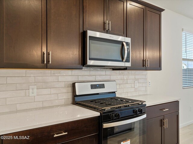 6647 E Camino Rebina, Tucson, AZ 85756 - kitchen featuring baseboards, backsplash, dark brown cabinetry, and stainless steel appliances