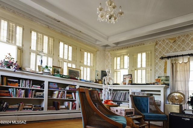 interior space featuring hardwood / wood-style floors, a healthy amount of sunlight, crown molding, and an inviting chandelier