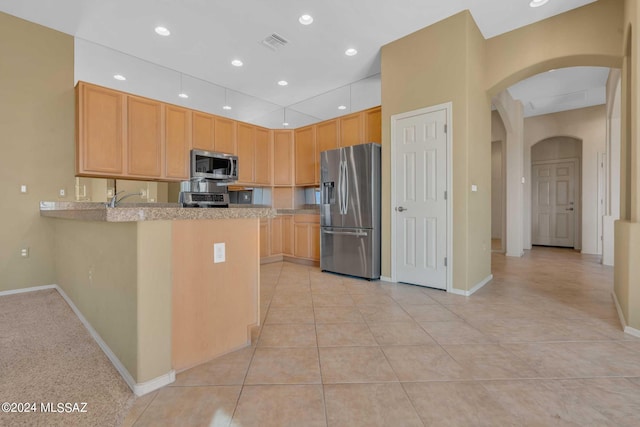 kitchen featuring stainless steel appliances, light brown cabinetry, sink, kitchen peninsula, and light tile patterned floors