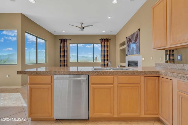 kitchen featuring stainless steel dishwasher, kitchen peninsula, sink, light tile patterned floors, and light brown cabinetry