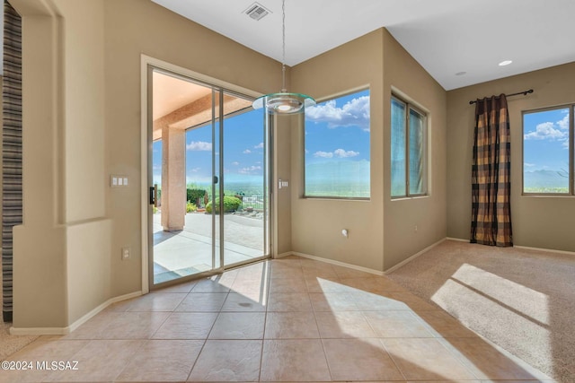 entryway with a wealth of natural light and light tile patterned floors