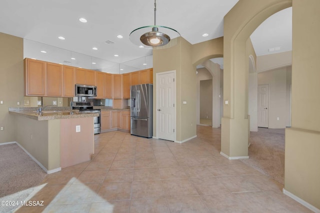 kitchen featuring kitchen peninsula, sink, appliances with stainless steel finishes, light carpet, and light stone counters