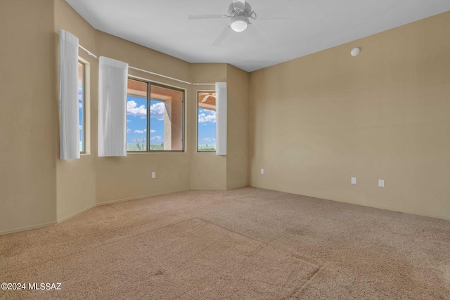 carpeted spare room with ceiling fan