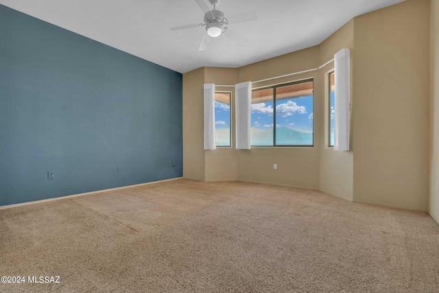 carpeted spare room with ceiling fan