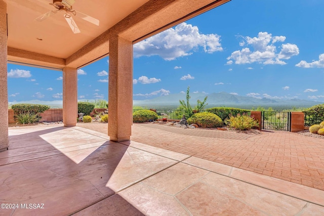 view of patio featuring ceiling fan and a mountain view