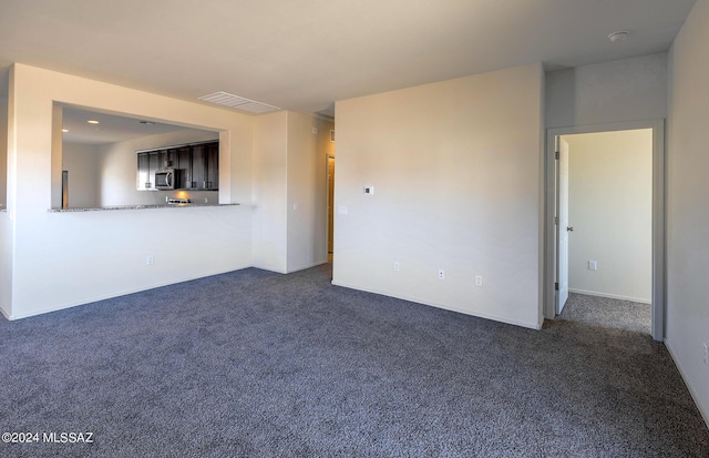 unfurnished living room featuring dark carpet