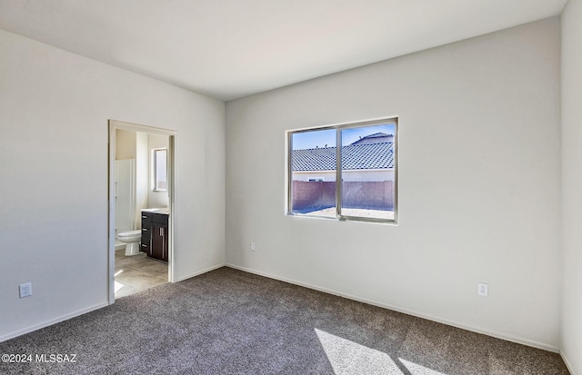 unfurnished bedroom featuring light carpet and ensuite bath