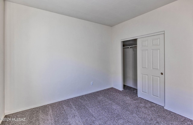 unfurnished bedroom featuring carpet flooring and a closet