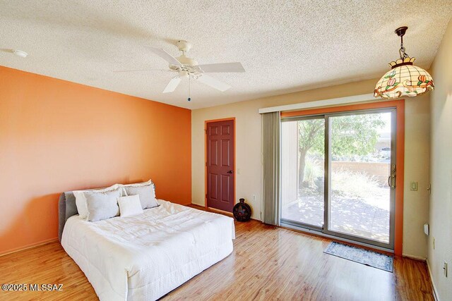 bedroom with a textured ceiling, ensuite bathroom, light hardwood / wood-style flooring, and ceiling fan