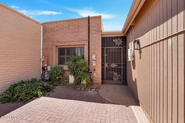 doorway to property with brick siding