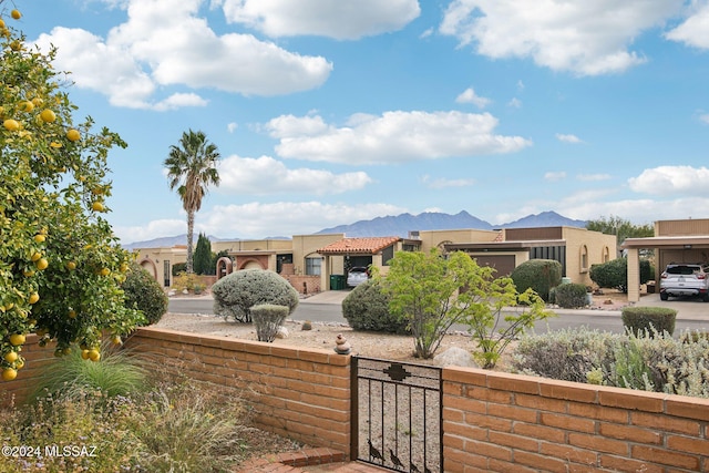 view of yard with a fenced front yard, a gate, and a mountain view