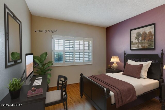 bedroom with light hardwood / wood-style floors and a textured ceiling