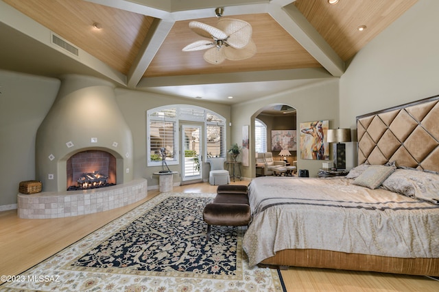 bedroom featuring a tile fireplace, ceiling fan, wooden ceiling, and wood-type flooring