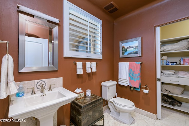 bathroom featuring tile patterned flooring, toilet, and sink