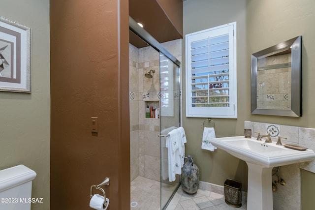 bathroom with sink, tile patterned flooring, toilet, and walk in shower