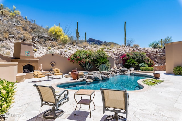 view of pool with a patio area and an outdoor fireplace