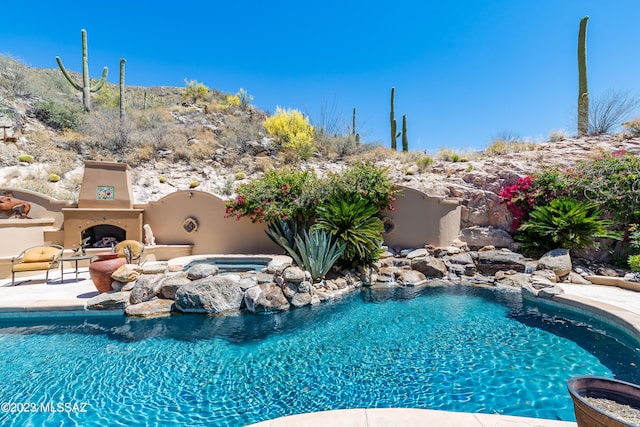 view of pool with a patio area and an outdoor fireplace