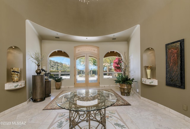 entryway featuring french doors and a towering ceiling