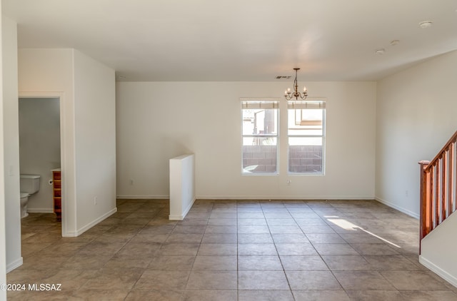 spare room with light tile patterned floors and a notable chandelier