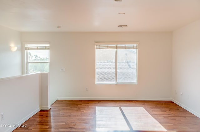 spare room featuring hardwood / wood-style flooring and a healthy amount of sunlight