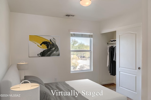 bedroom featuring dark colored carpet and a closet