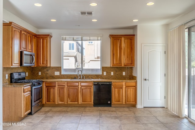 kitchen with a wealth of natural light, sink, and appliances with stainless steel finishes