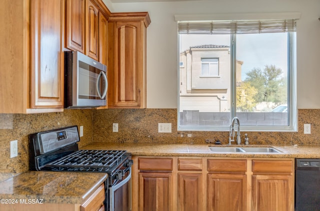 kitchen featuring black appliances, decorative backsplash, and sink