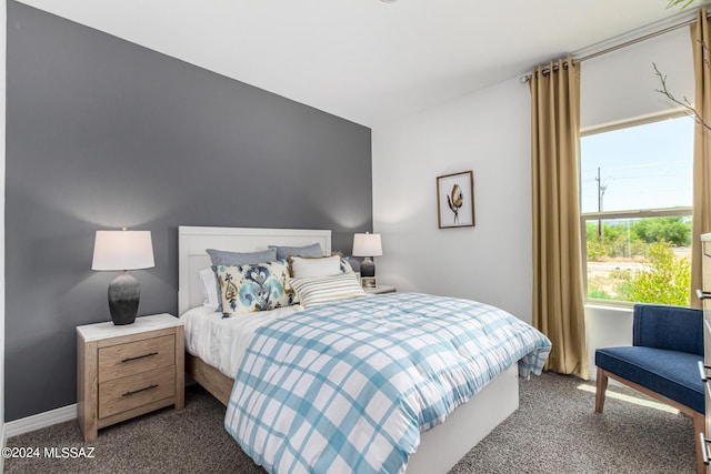 bedroom featuring baseboards and dark colored carpet