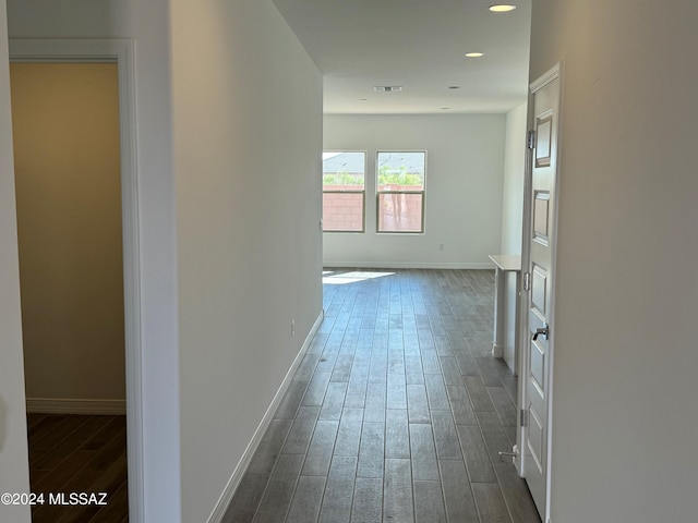 hall with recessed lighting, visible vents, baseboards, and dark wood-style floors