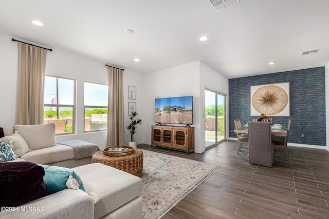 living area featuring visible vents, recessed lighting, an accent wall, and baseboards