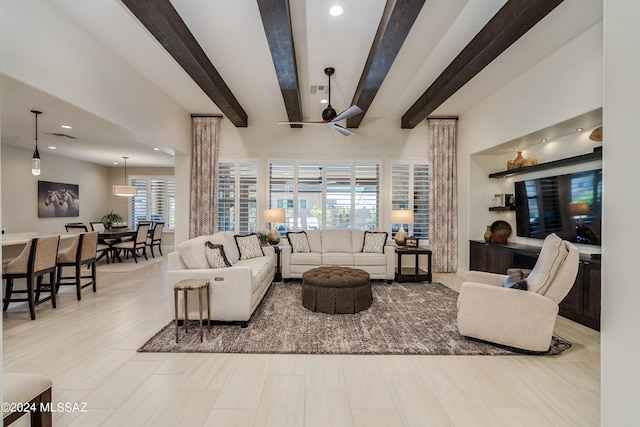 living room with beam ceiling, plenty of natural light, and ceiling fan