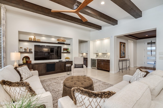 living room with beamed ceiling, ceiling fan, beverage cooler, and light hardwood / wood-style flooring