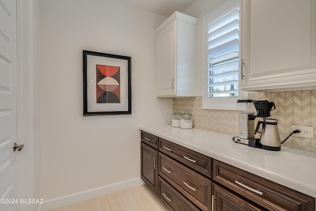 kitchen with decorative backsplash, dark brown cabinetry, and white cabinetry