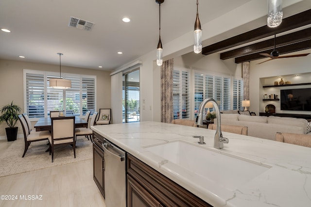 kitchen with sink, stainless steel dishwasher, decorative light fixtures, beam ceiling, and light stone counters