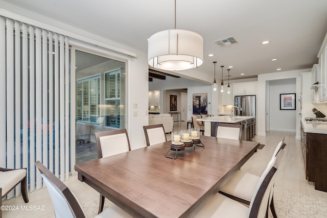 dining space with light hardwood / wood-style flooring and sink