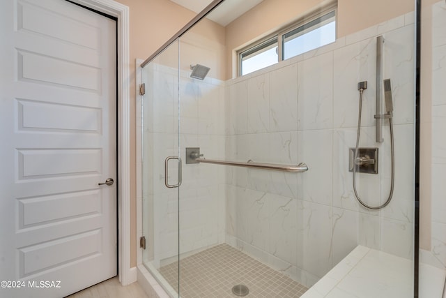 bathroom with a shower with door