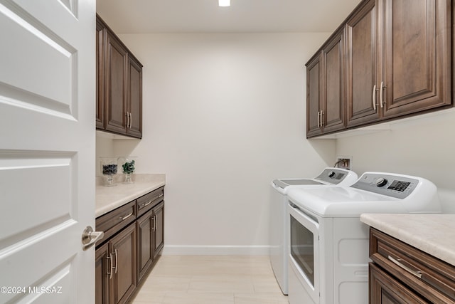 laundry area featuring washer and dryer and cabinets