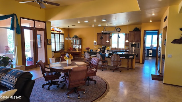 tiled dining room featuring ceiling fan with notable chandelier