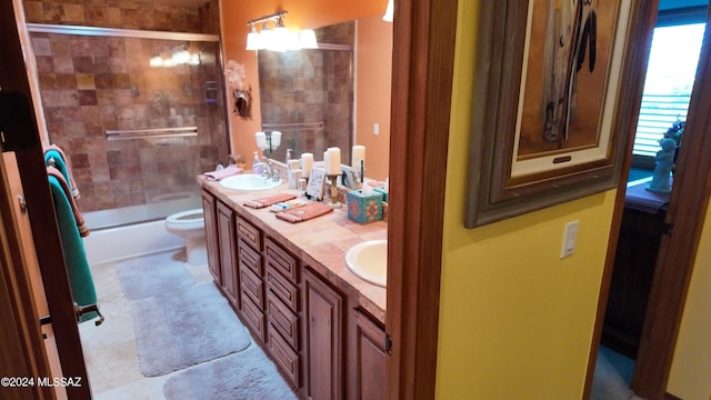 full bathroom featuring vanity, toilet, and bath / shower combo with glass door