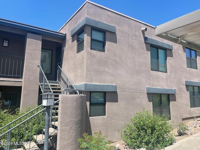 view of property exterior featuring stairway and stucco siding