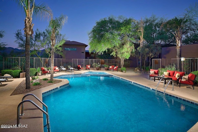 community pool with a patio, outdoor lounge area, and a fenced backyard