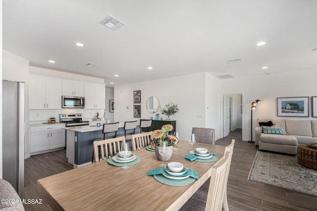 dining room featuring dark wood-style floors, visible vents, and recessed lighting