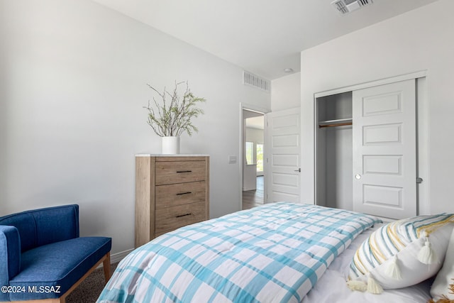 bedroom with a closet, visible vents, and baseboards