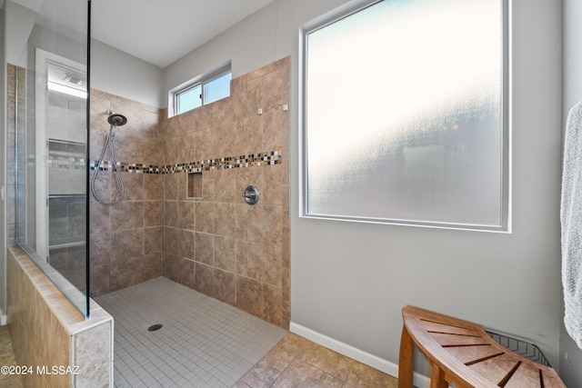 bathroom with tile patterned flooring and a tile shower