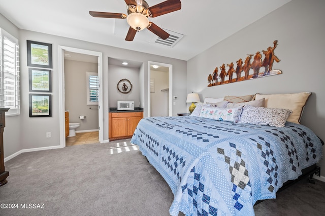 bedroom with carpet, ensuite bathroom, and ceiling fan