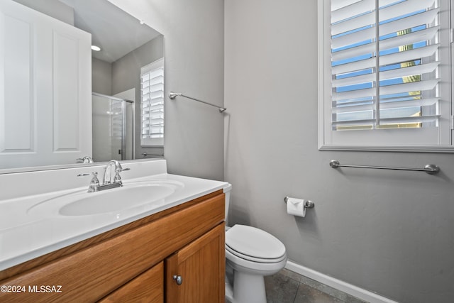 bathroom featuring tile patterned flooring, vanity, an enclosed shower, and toilet