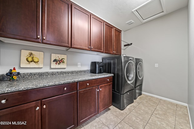 washroom with washer and clothes dryer, light tile patterned floors, and cabinets