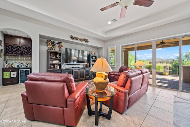 living room featuring bar area, light tile patterned floors, and wine cooler