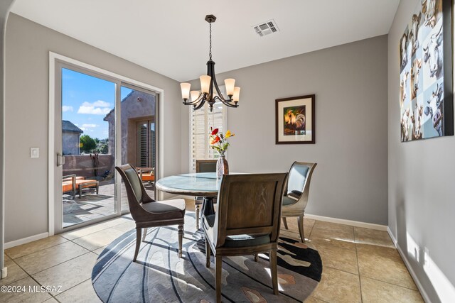 tiled dining area featuring a chandelier